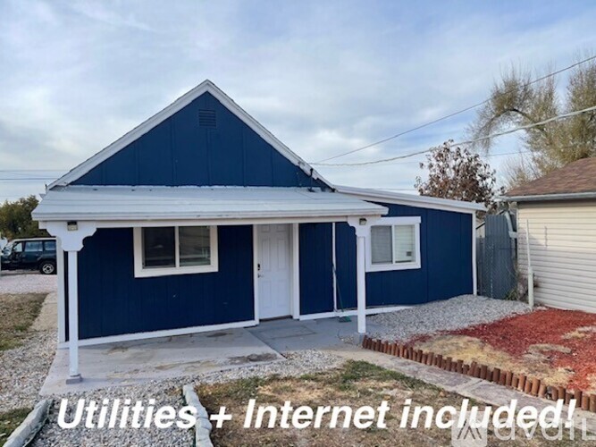 A blue house with a white door and windows.
