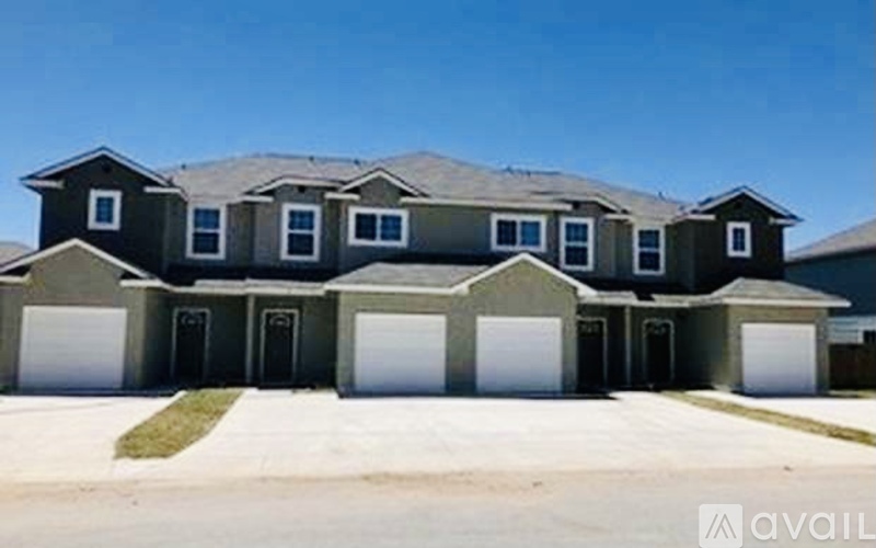 A large house with a grey roof and multiple garages.