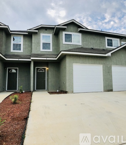 A modern house with a grey exterior and a white garage door.