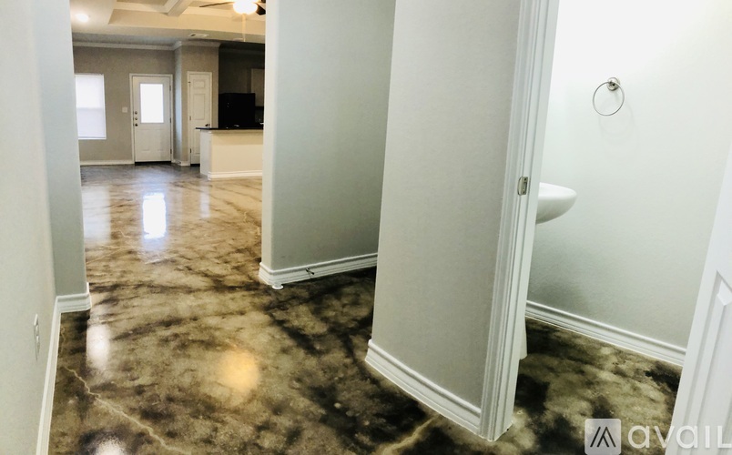 A bathroom with a marble floor and white walls.
