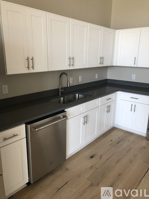 A kitchen with white cabinets and a stainless steel dishwasher.
