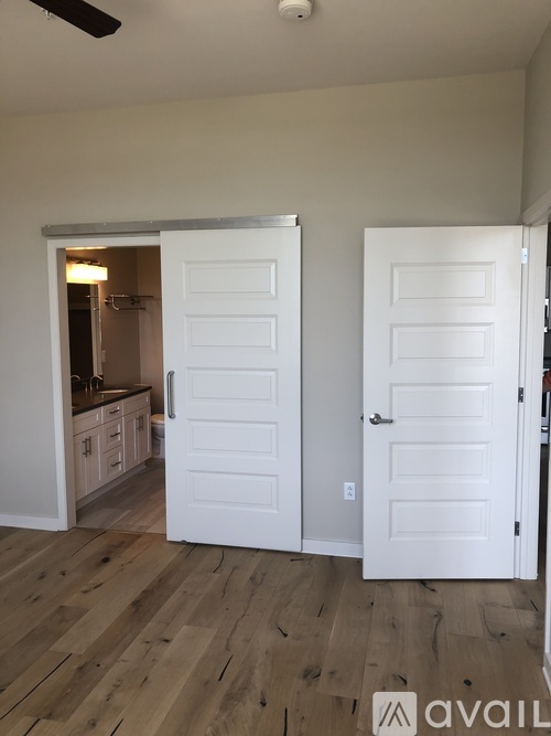 A room with two white doors and a wooden floor.