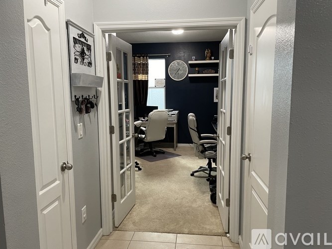A room with a white door and a clock on the wall.