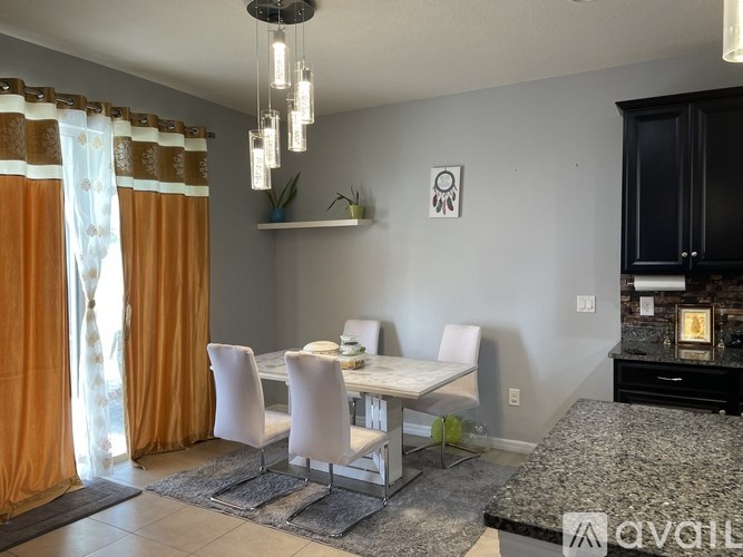 A modern dining room with a granite countertop and white chairs.