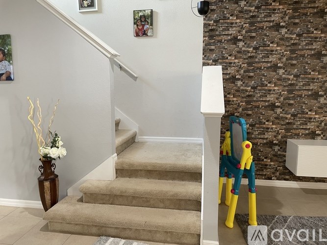 A staircase with a white railing and beige carpeted steps.