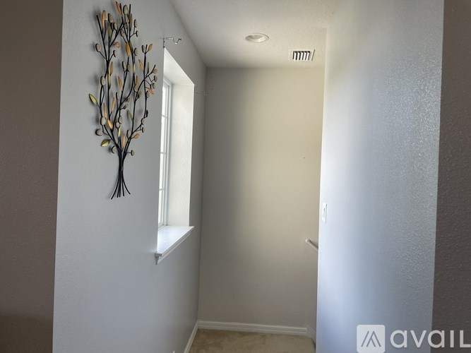A room with a wall art of a tree and a window.