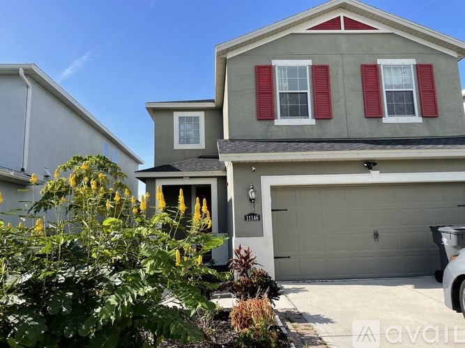 A house with a garage and a car parked in front.