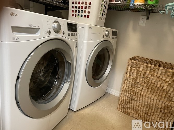 Two white LG front load washing machines in a laundry room.