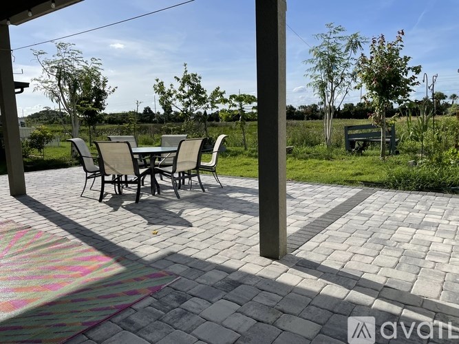 A patio with a table and chairs is covered by a roof.