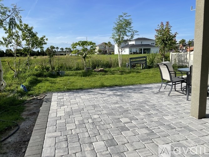 A backyard with a patio and a bench.
