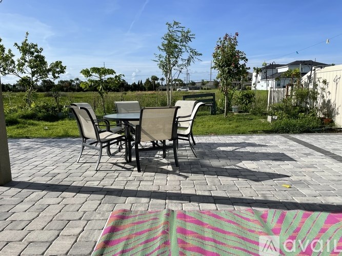 A patio with a table and chairs is set up on a brick patio.