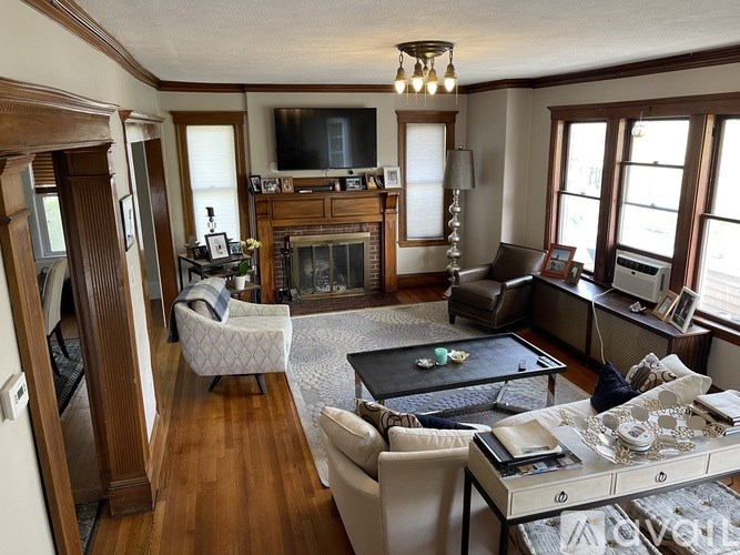 A living room with a fireplace and a television.