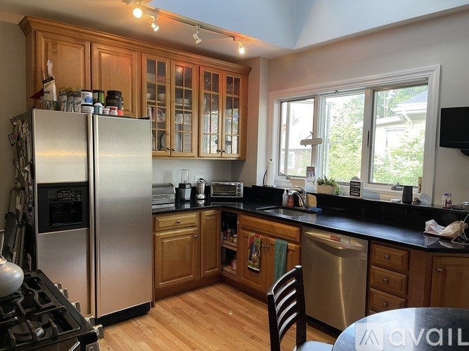 A kitchen with wooden cabinets and a stainless steel refrigerator.