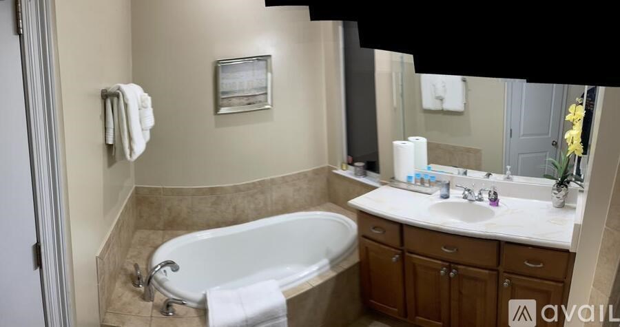 A bathroom with a tub, sink, and mirror.