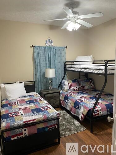 A bedroom with two beds and a ceiling fan.