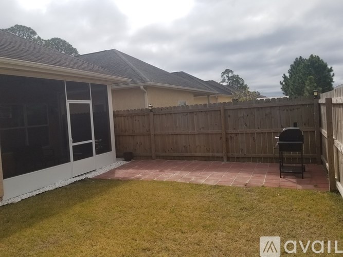 A backyard with a patio and a fence.