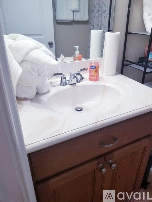 A white towel is hanging on a bathroom sink.