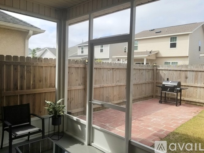 A patio with a table and chairs is shown through a sliding glass door.
