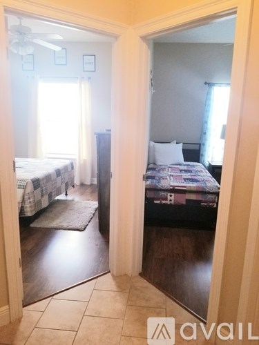 A bedroom with a bed and a rug is visible through an open door.