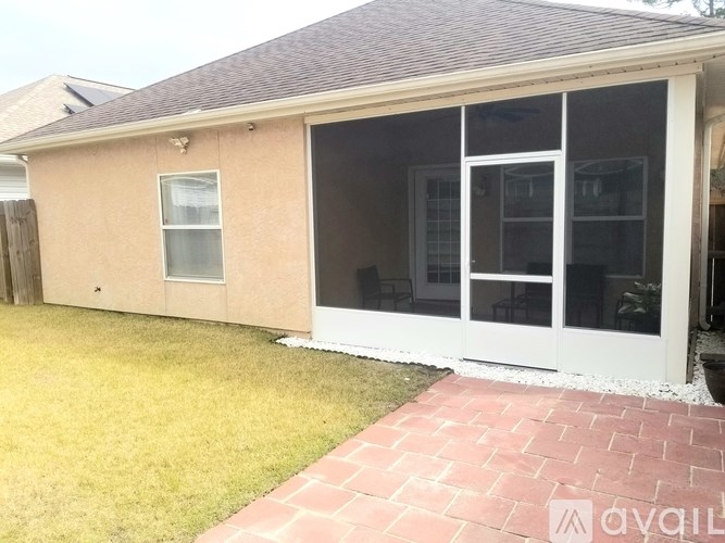 A house with a white patio door and a brick walkway.