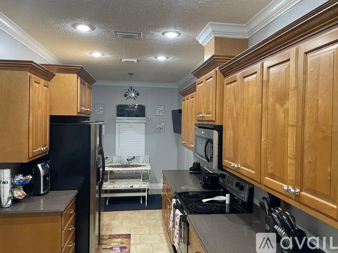 A kitchen with wooden cabinets and black appliances.