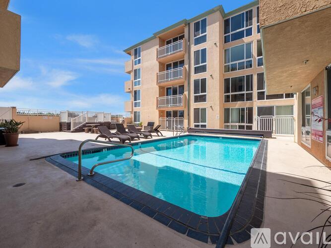A swimming pool in front of a multi-story apartment building.