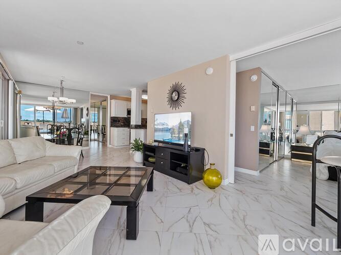 A modern living room with a glass table and a white sofa.