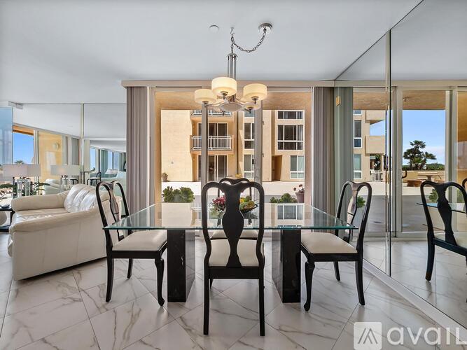A modern dining room with a glass table and chairs.