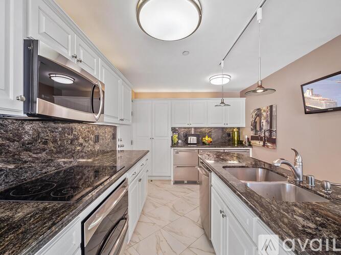 A kitchen with granite countertops and white cabinets.