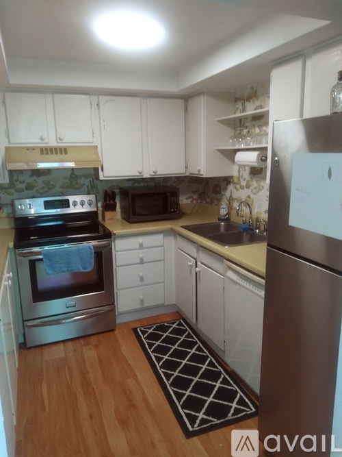 A kitchen with a stove top oven, microwave, and refrigerator.