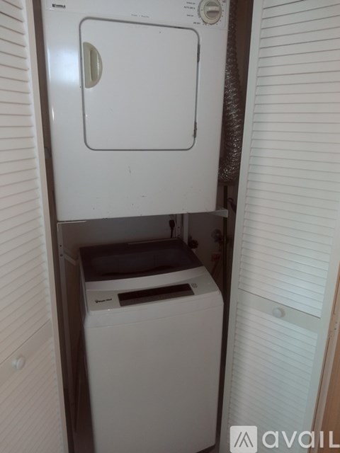 A white dryer and washing machine in a small space.