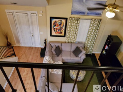 A living room with a couch and a painting on the wall.