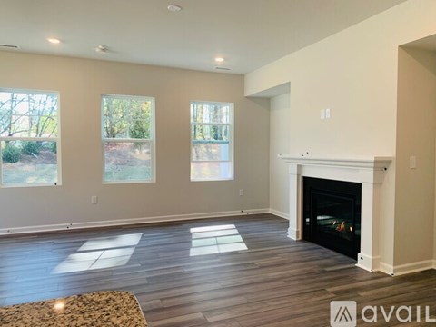 A living room with a fireplace and a rug on the floor.