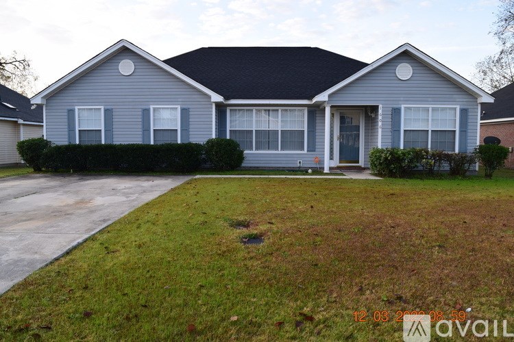 A house with a grey roof and a green lawn in front.