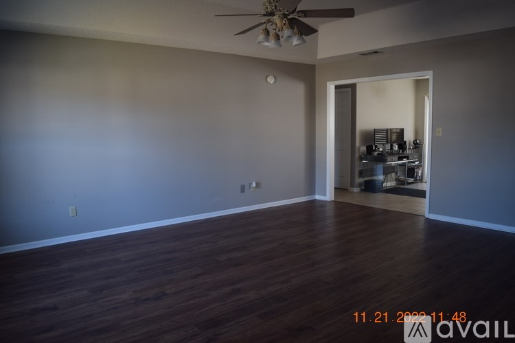 A room with a ceiling fan and wooden flooring.