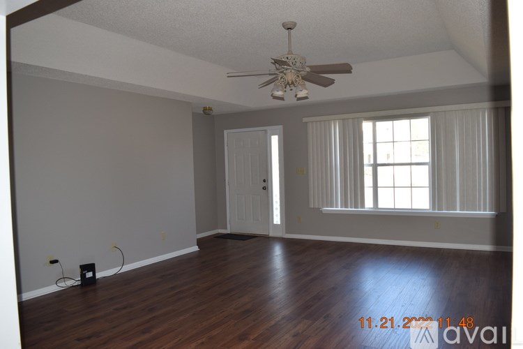 A room with a ceiling fan and a window with blinds.