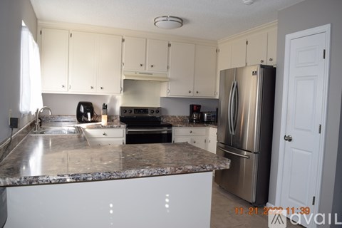 A kitchen with a granite countertop and stainless steel appliances.