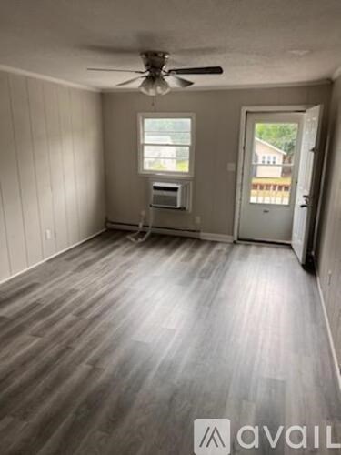 A room with a ceiling fan and a window.