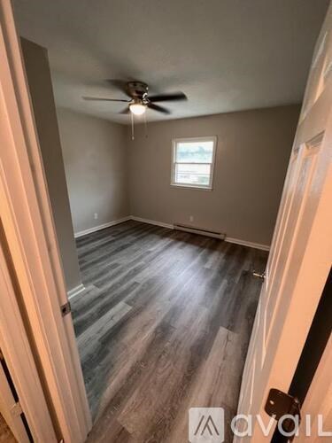 A room with a ceiling fan and a window.