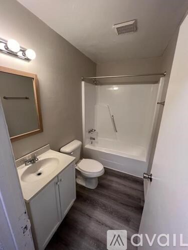 A bathroom with a toilet, sink, and bathtub.