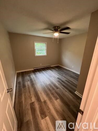 A room with wooden flooring and a ceiling fan.