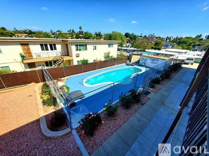 A pool surrounded by a fence and bushes.