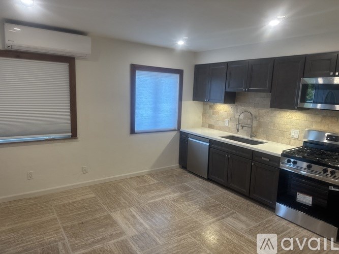 A room with tiled flooring and a window with blinds.
