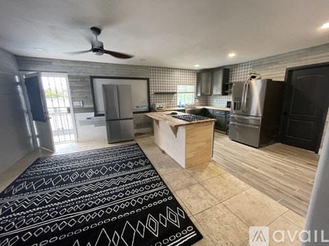 A kitchen with a black and white patterned rug on the floor.