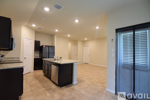 A kitchen with black cabinets and a countertop with a sink.
