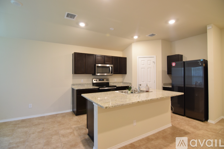 A kitchen with a white counter top and black appliances.