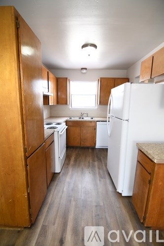 A kitchen with wooden cabinets and a white refrigerator.