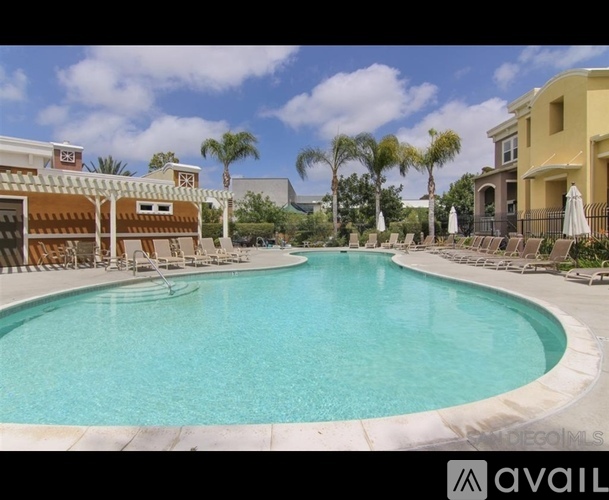 A large swimming pool surrounded by lounge chairs and umbrellas.