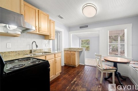 A kitchen with wooden cabinets and a black stove top oven.