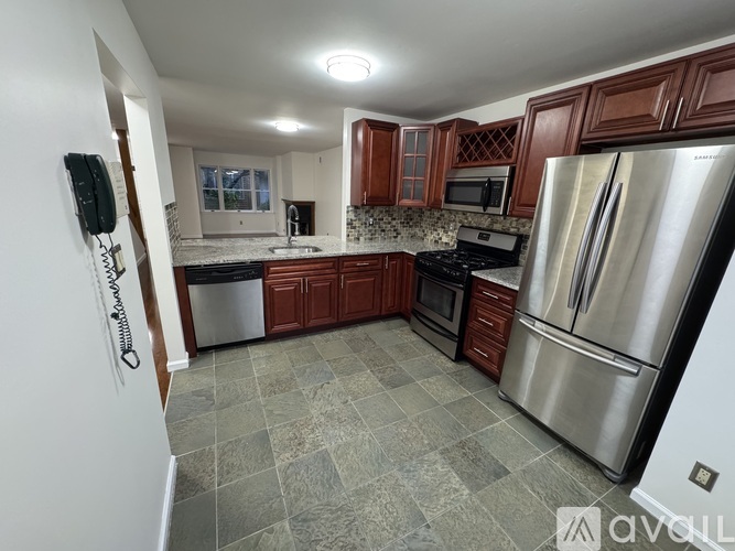 A kitchen with a refrigerator, oven, and microwave.